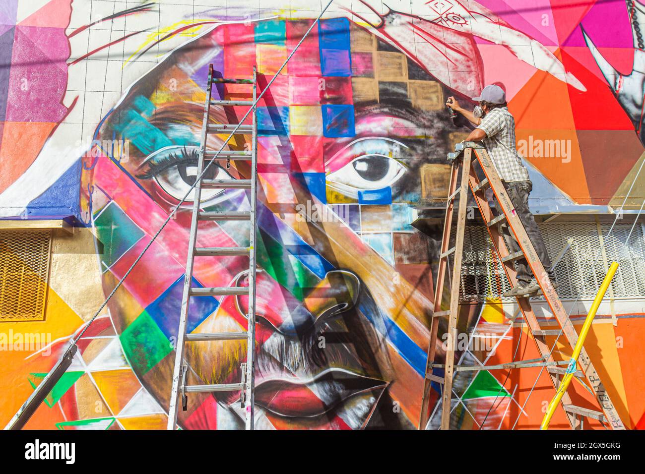 Miami Florida,Wynwood Art District Basel,muralist wall mural spray painting Black man male,artist painter contemporary artwork colorful using ladders Stock Photo