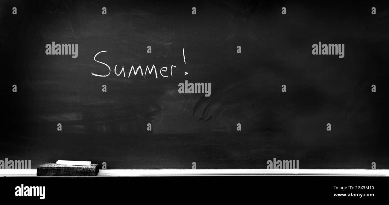 Chalkboard in school for education with eraser and chalk writing summer vacation summertime Stock Photo