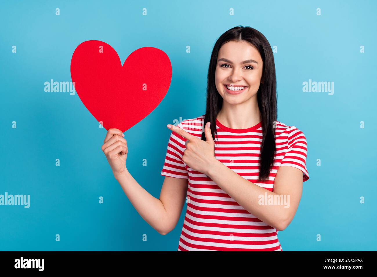 Photo of young girl happy smile point finger big red paper heart love ...