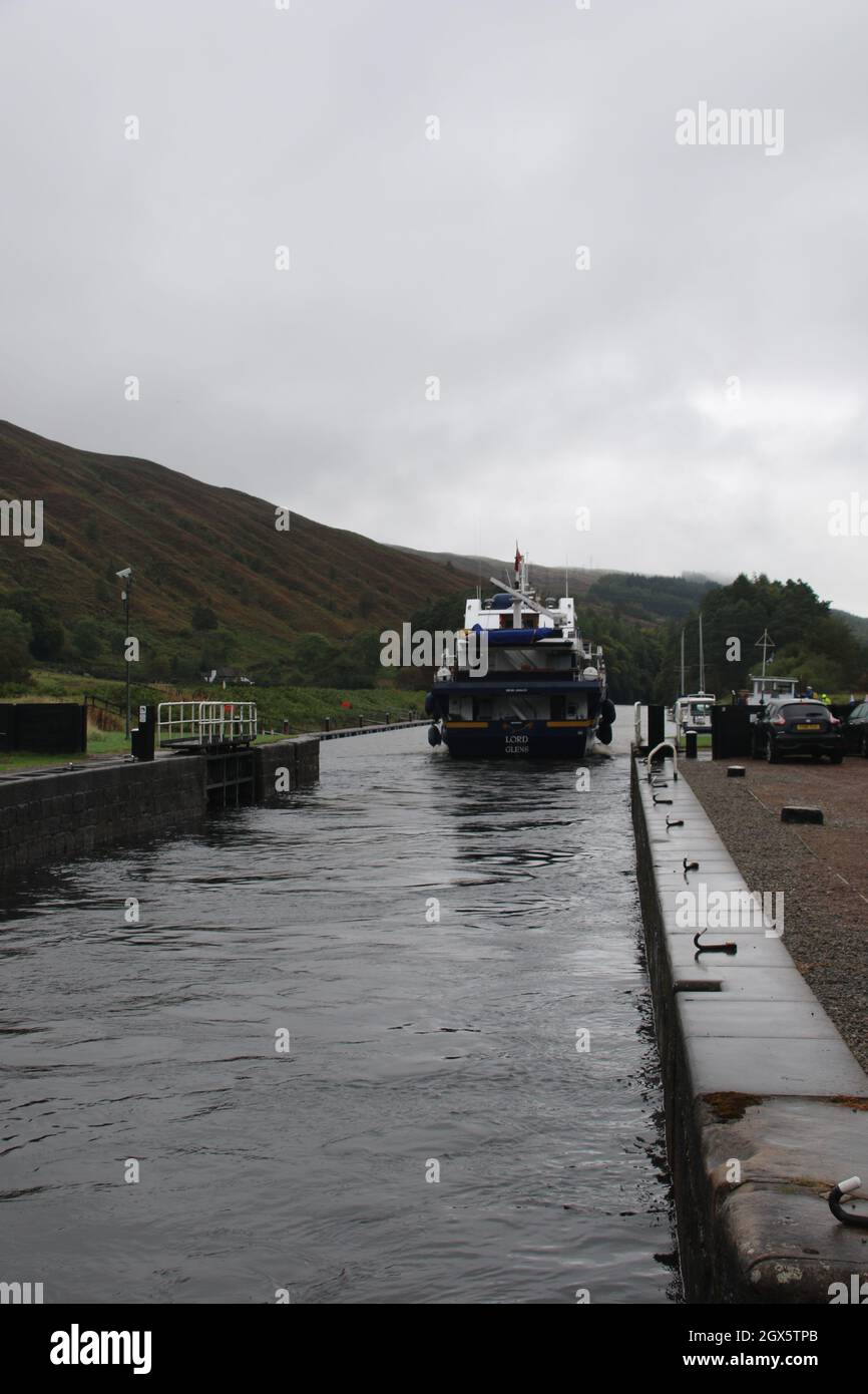 boat leaving Caledonian Canal lock at Loch Locky Stock Photo