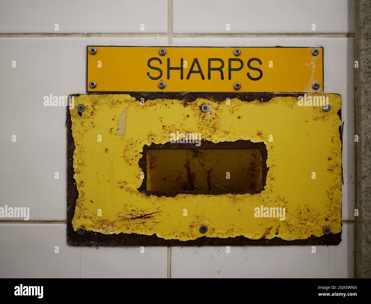 Sharps needle disposal bin in public toilet Stock Photo