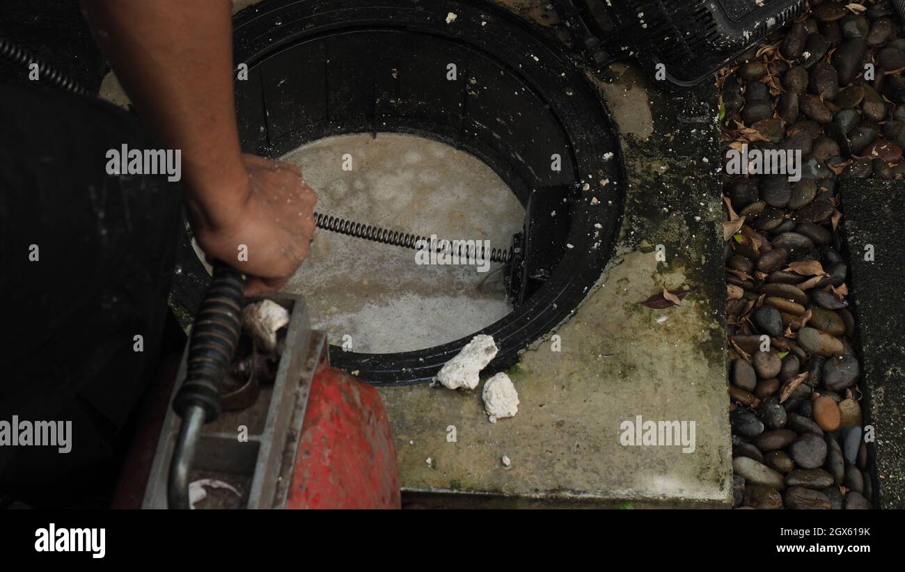https://c8.alamy.com/comp/2GX619K/drain-cleaning-plumber-repairing-clogged-grease-trap-with-auger-machine-maintenance-the-sewage-system-and-grease-trap-by-professional-plumber-using-2GX619K.jpg