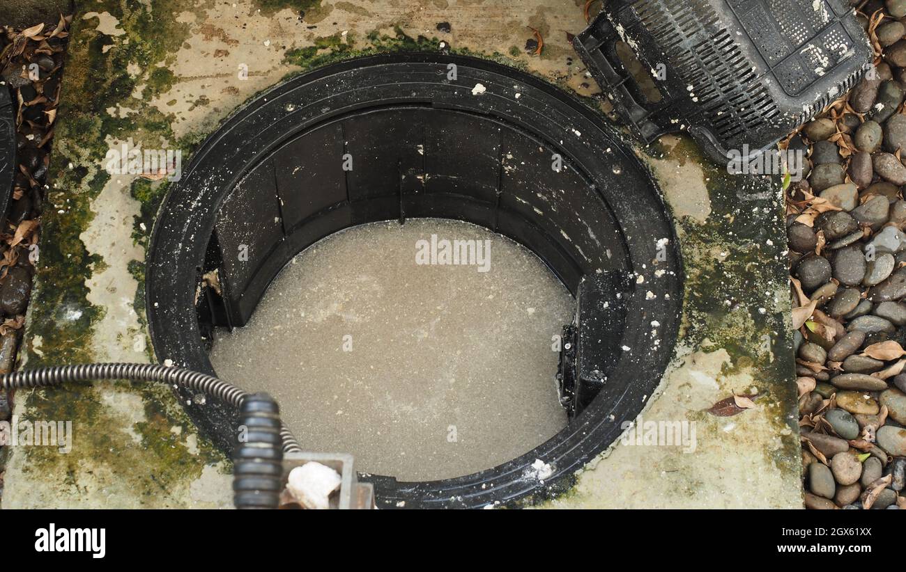 Drain cleaning. Plumber repairing clogged grease trap with auger