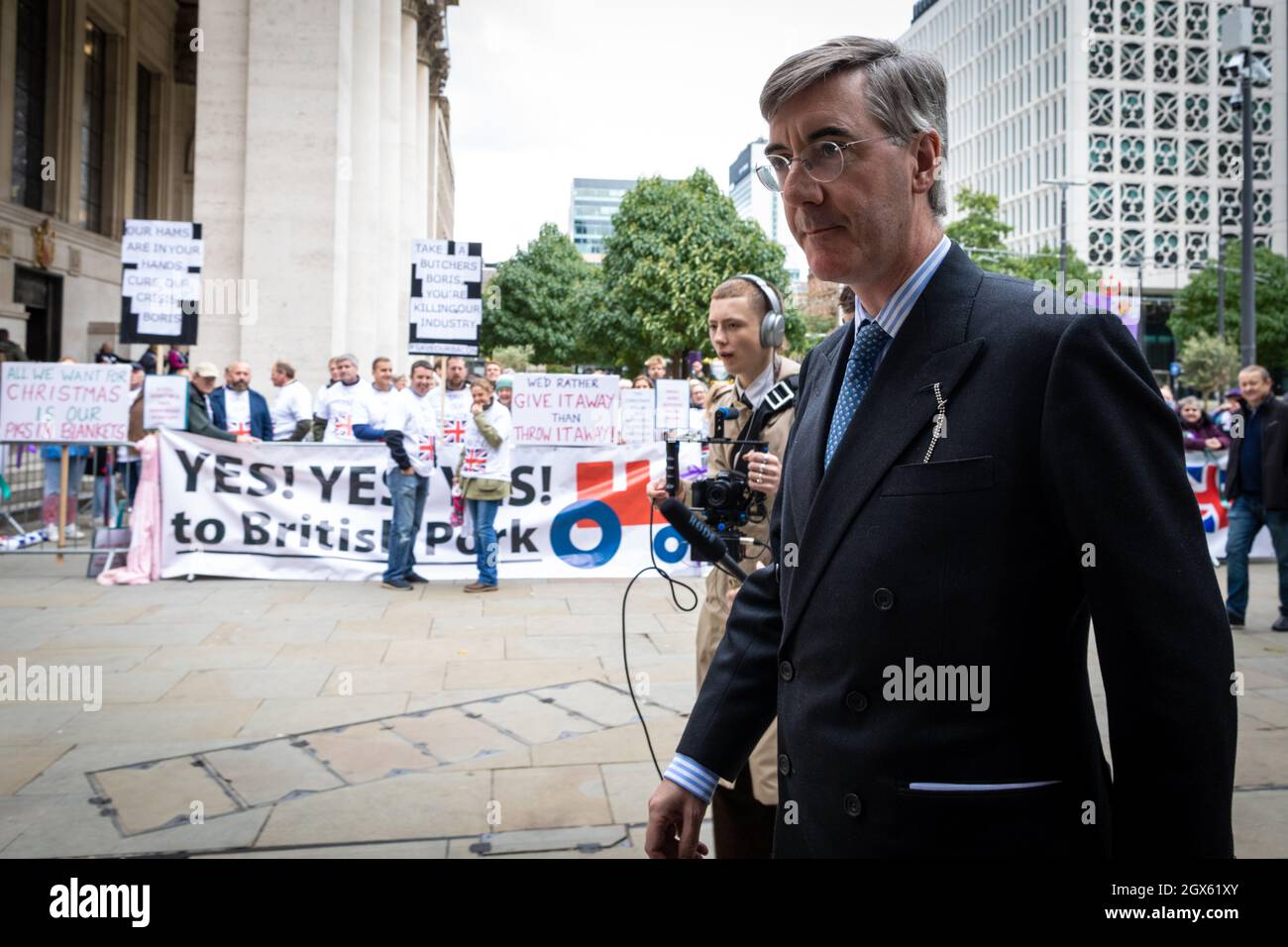 Manchester, UK. 04th Oct, 2021. Jacob Rees-Mogg walks towards the Conservative Party Conference past pig farmers who are protesting outside the event. British farmers protest against the Tory Party due to implications caused by Brexit, which has resulted in skills shortages and restrictions.ÊAndy Barton/Alamy Live News Credit: Andy Barton/Alamy Live News Stock Photo