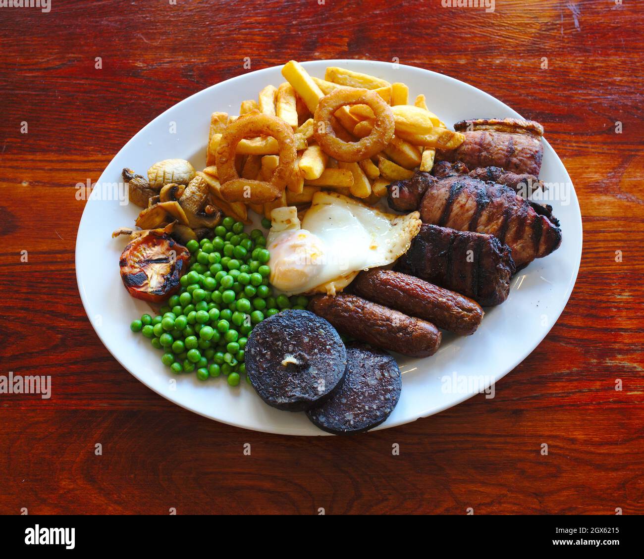 Traditional English food plate of mixed grilled meat, chips, eggs and
