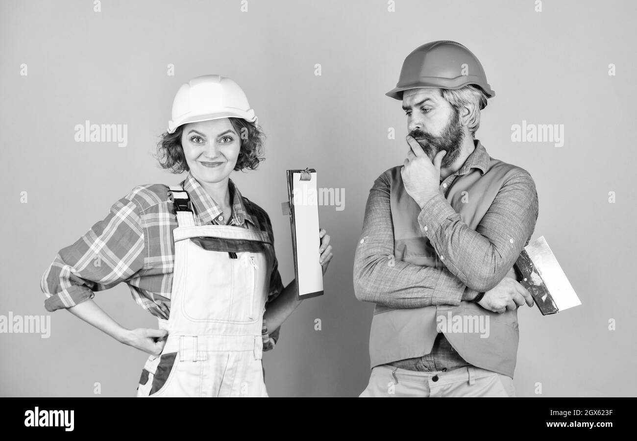 Woman and man safety hard hat. Discussing renovation with contractor. Sign contract with workers