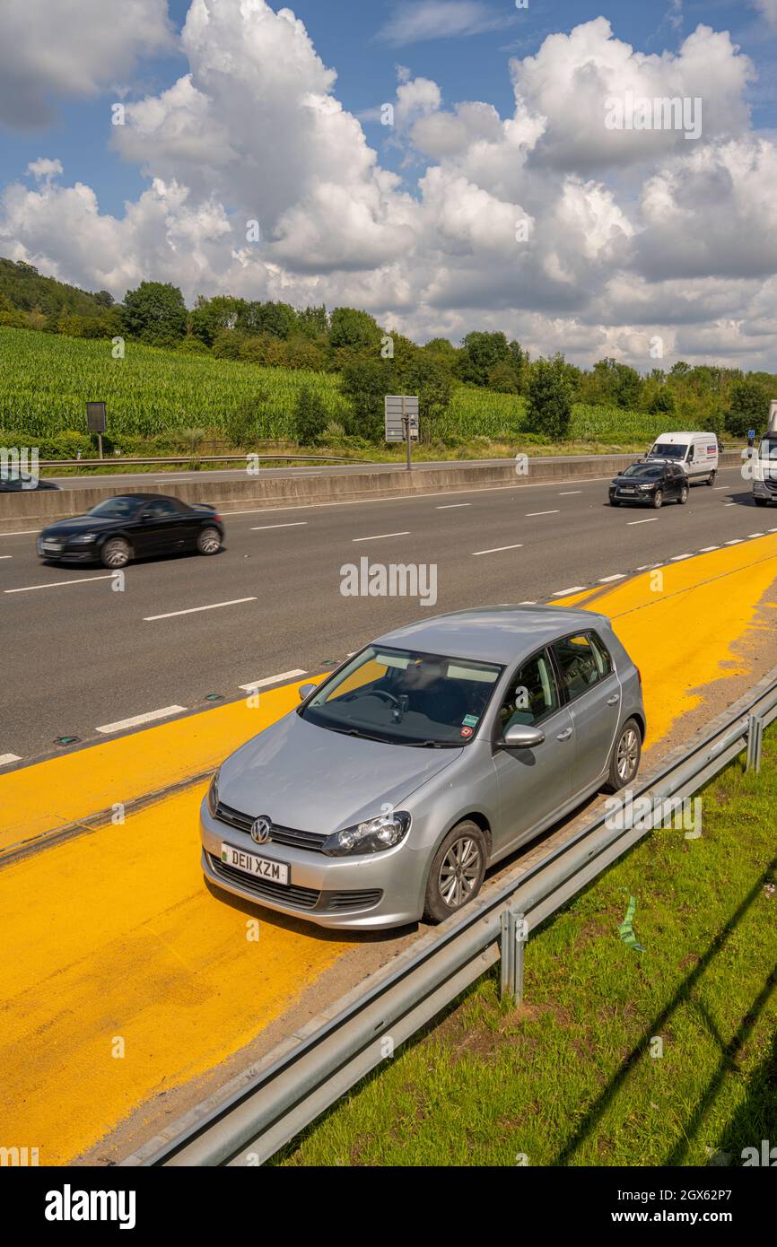 A broken down VW Golf parked in the safety refuge area on the M25 near Godstone Surrey. Stock Photo