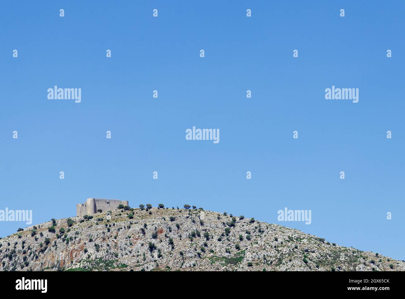 Aged castle on a rocky hill under the plain blue sky Stock Photo - Alamy