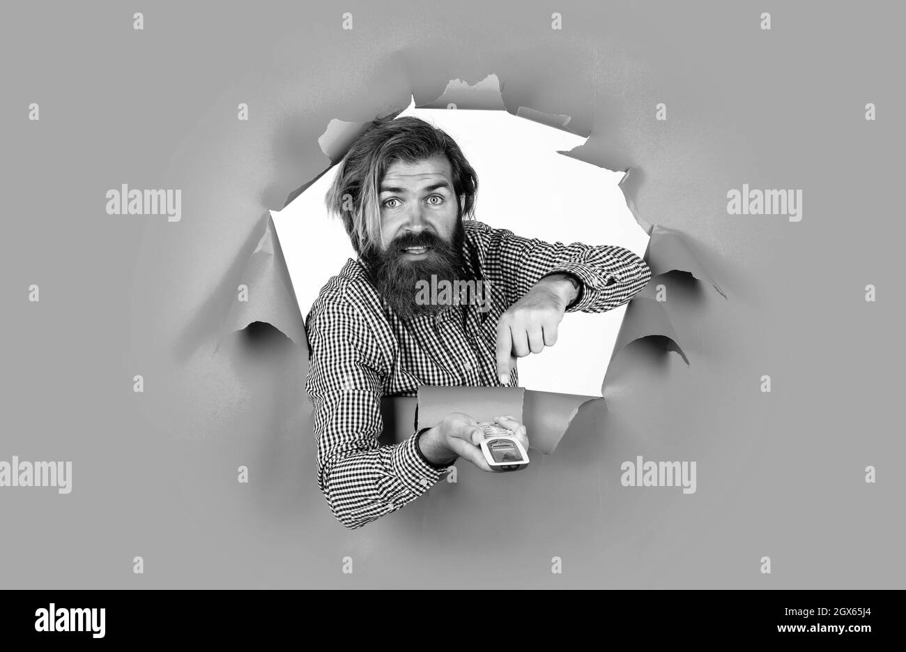 bearded brutal man with moustache use remote controle, smart technology Stock Photo