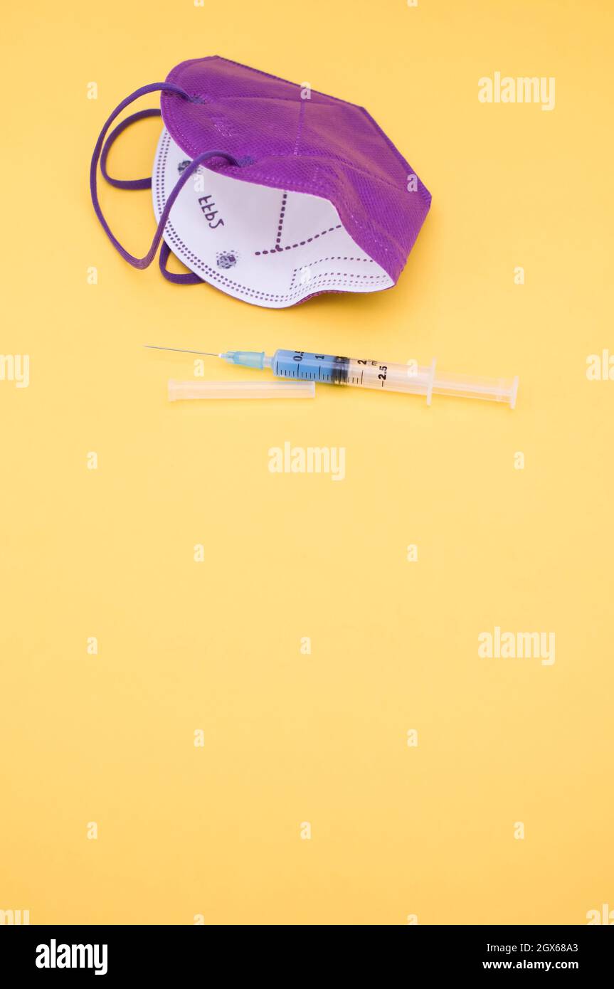 Isolated respiratory mask and syringe on a yellow background Stock ...
