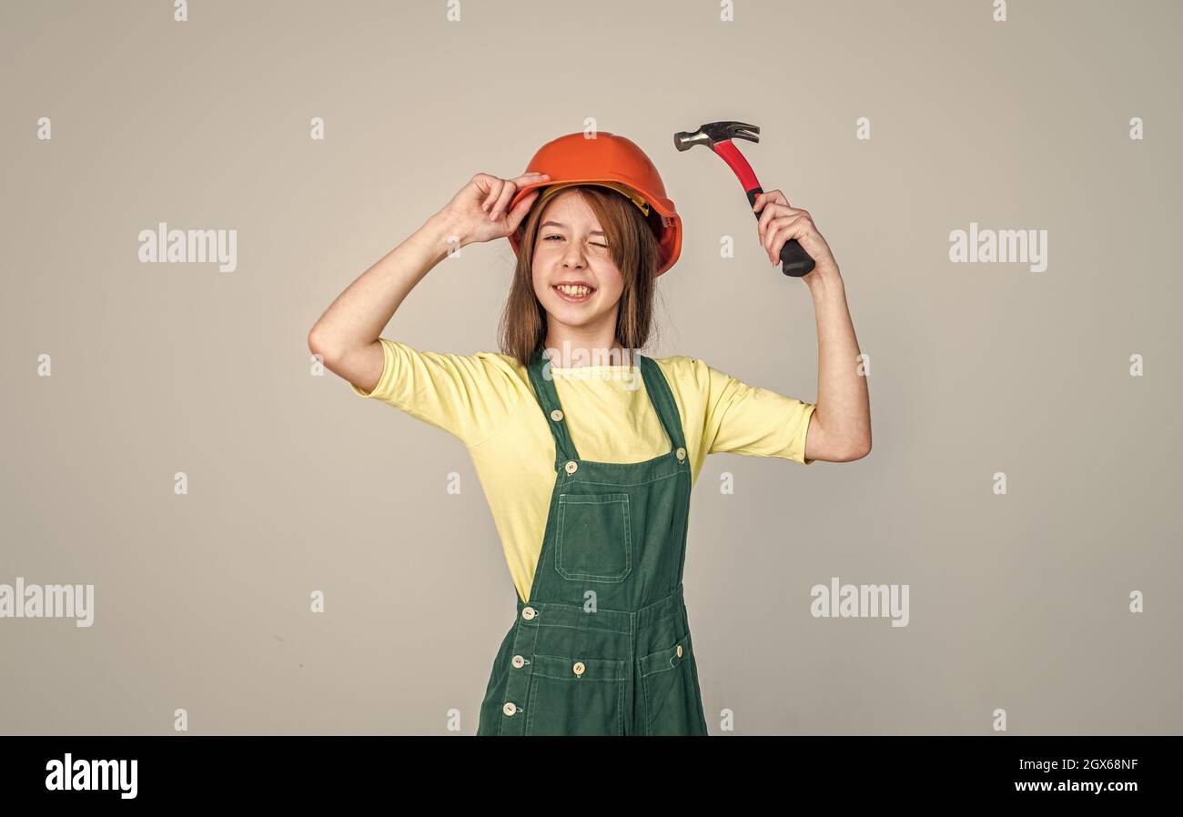 cheerful teen girl in working uniform and helmet use hammer, repair Stock  Photo - Alamy