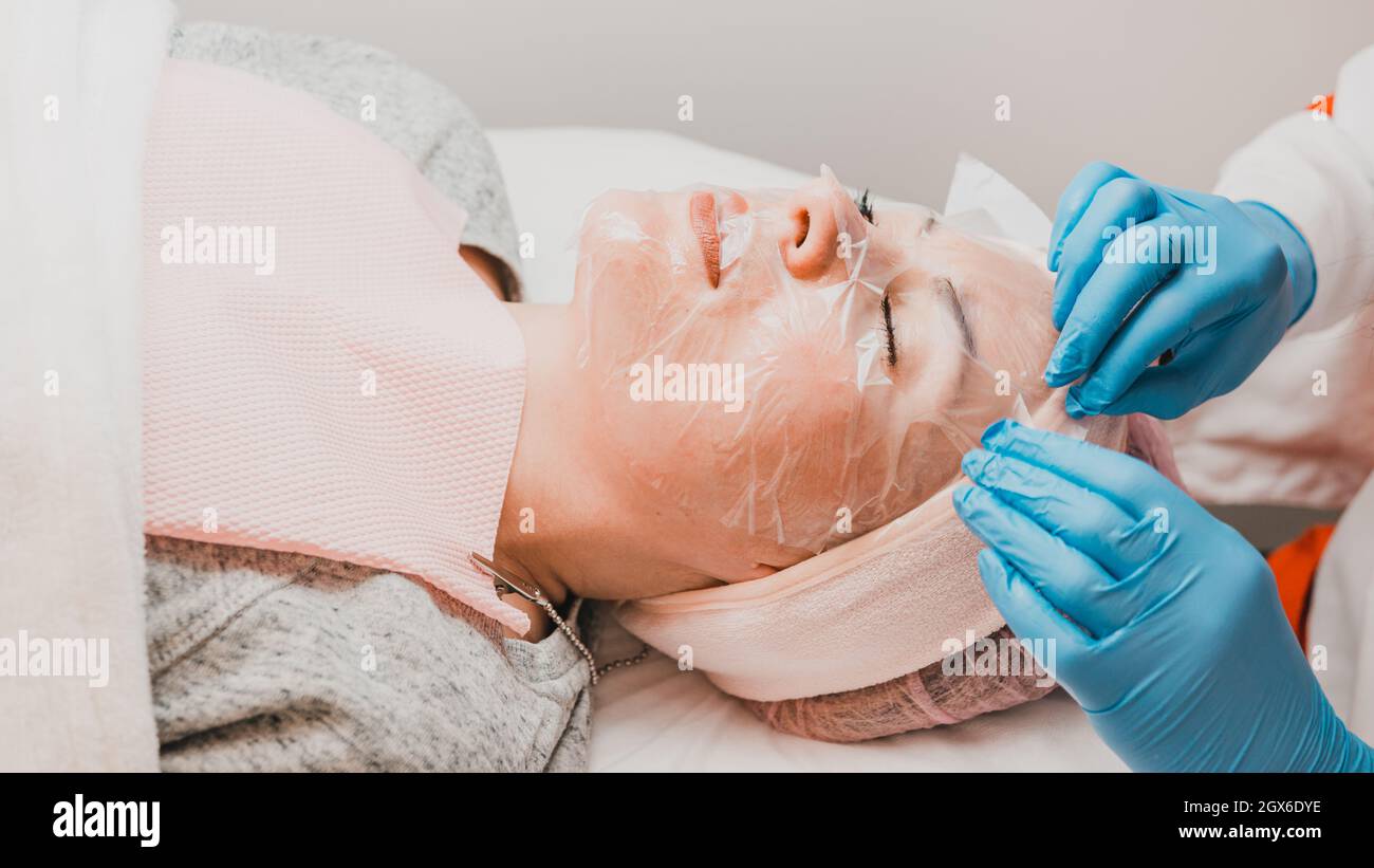 Applying a film mask on the face to steam and open pores, visit the spa