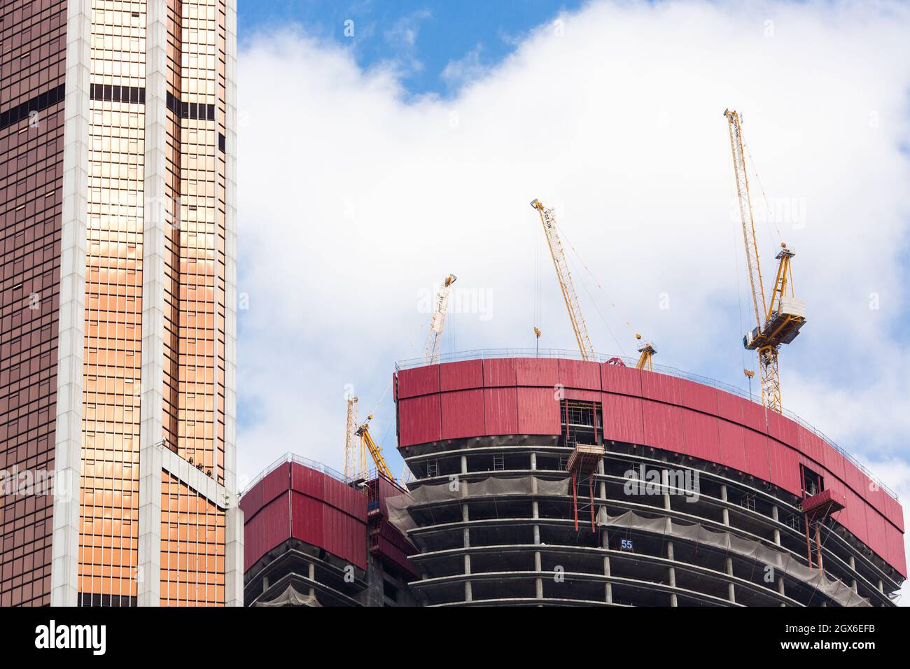 Moscow, Russia - October 4, 2021: Low angle view of construction site with skyscraper and tower cranes. Stock Photo