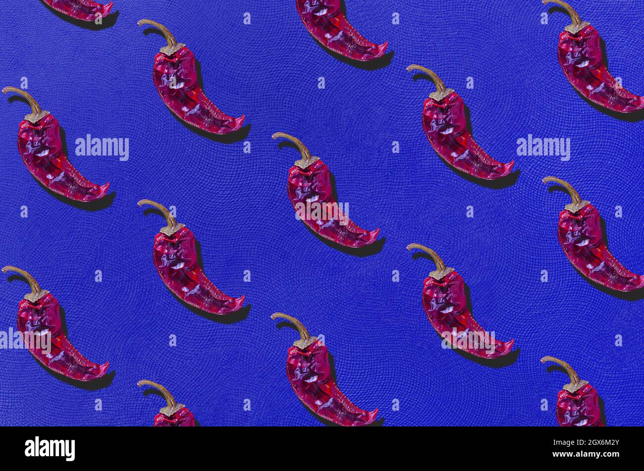 Dry red chili peppers on azure blue texture background. Flat lay. Minimal organic vegetable concept. Stock Photo