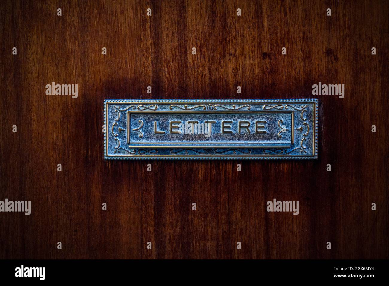 Italian postbox, vintage metal postbox on wooden door Stock Photo