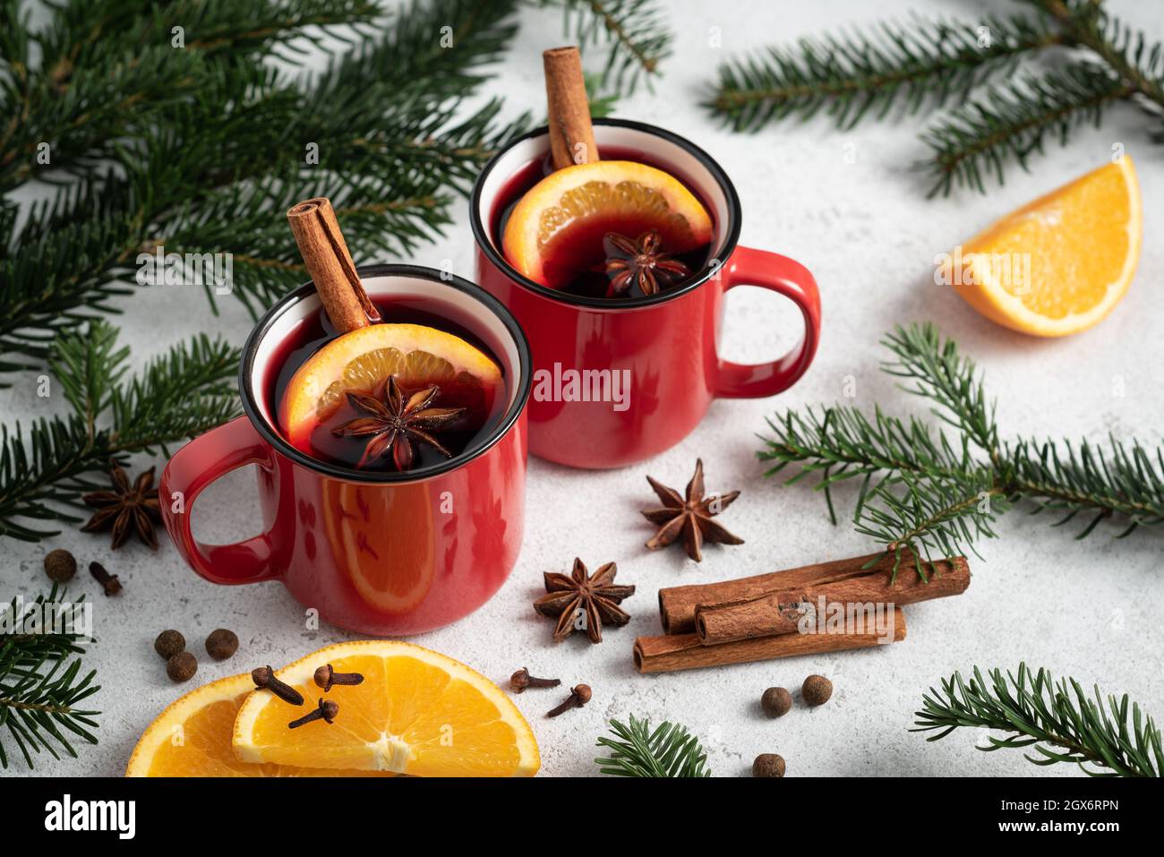 Christmas card with mulled wine in red cups on a white table with fir branches Stock Photo