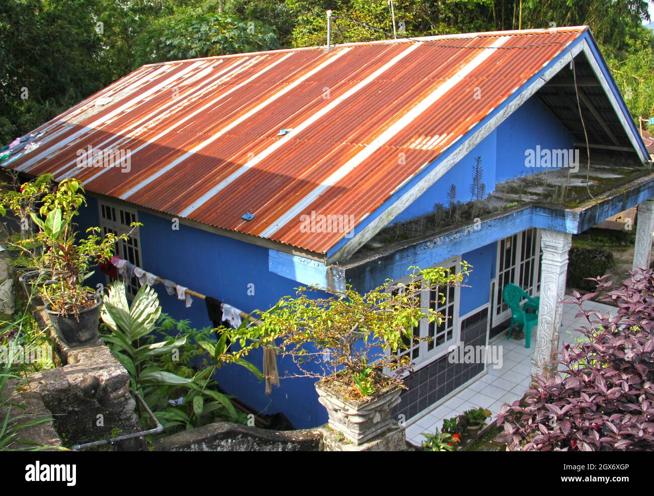 A blue house with a rusty iron roof in Bukittinggi in West Sumatra, Indonesia. Stock Photo