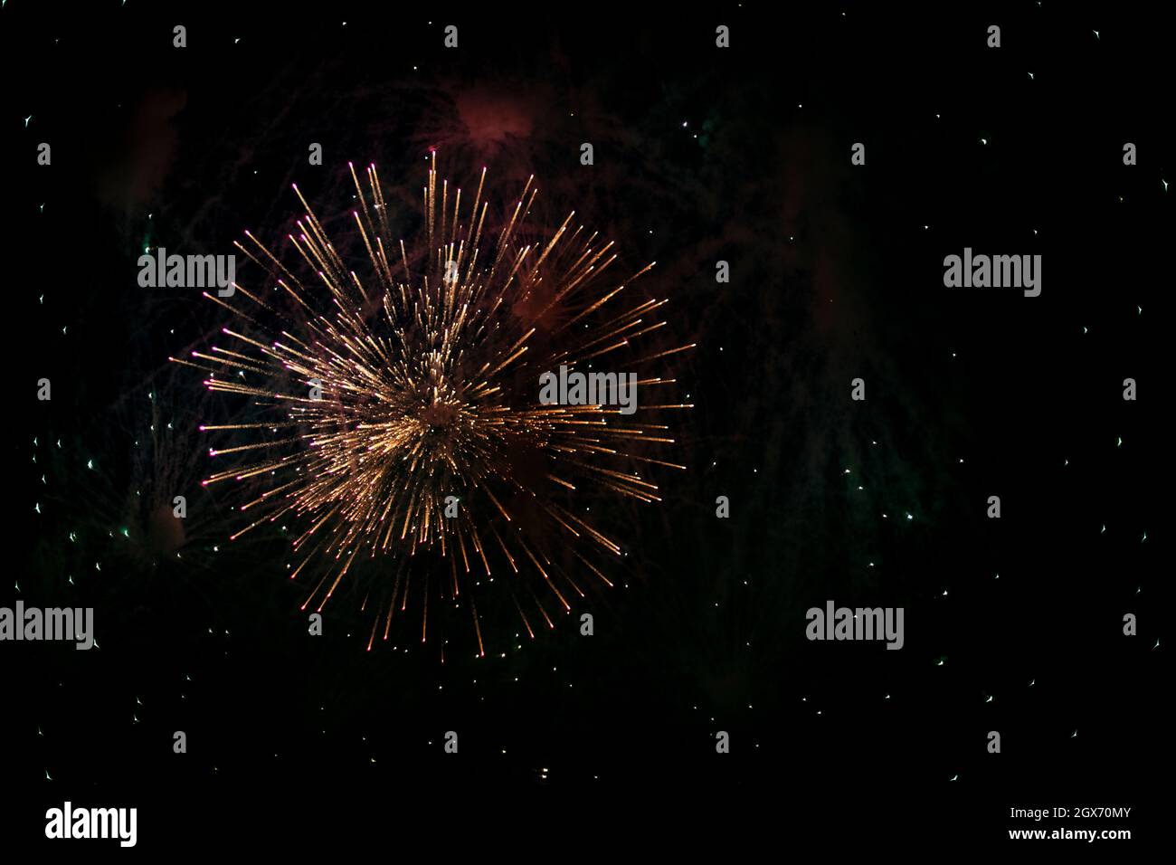 Salute in the sky. Explosion of fireworks in the night sky. Firecrackers flapping sparks in a dark space. Festive fireworks. Background with sparks fr Stock Photo