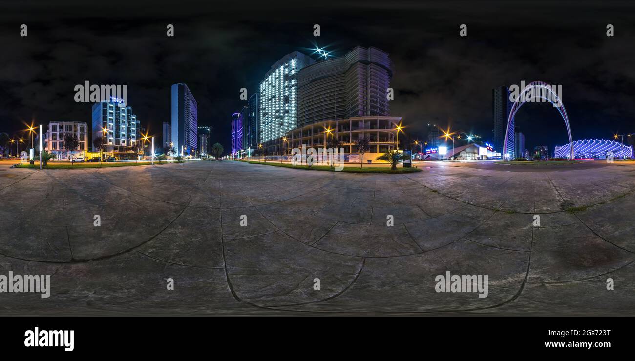 BATUMI, GEORGIA - SEPTEMBER 2021: full seamless spherical night 360 panorama on square among modern glowing skyscrapers and office buildings in equire Stock Photo