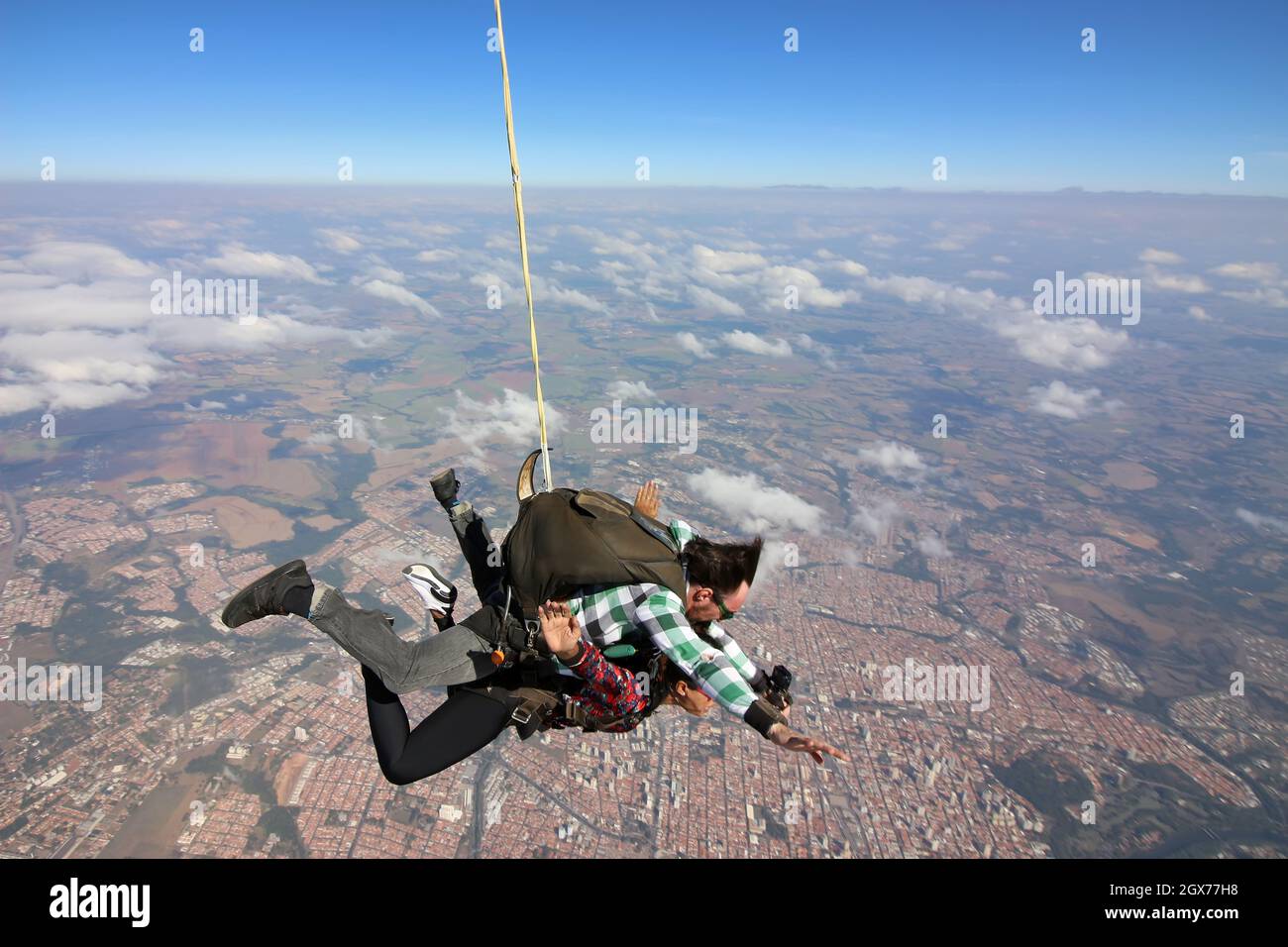 Tandem parachute jump. Beautiful Brazilian woman. Stock Photo