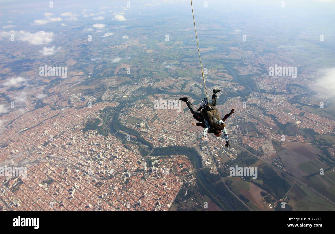 Tandem parachute jump. Beautiful Brazilian woman. Stock Photo