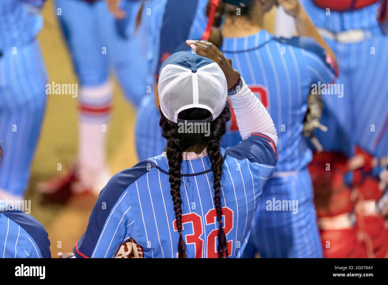 An Image Of A Softball Player Female Athlete Pitcher Is Winding Up To Deliver a Pitch To The Plate Stock Photo