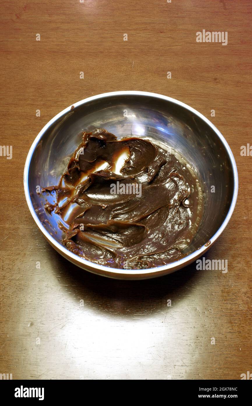 Chocolate for brigadeiro in a stainless steel bowl closeup. Typical Brazilian sweet home made. Stock Photo