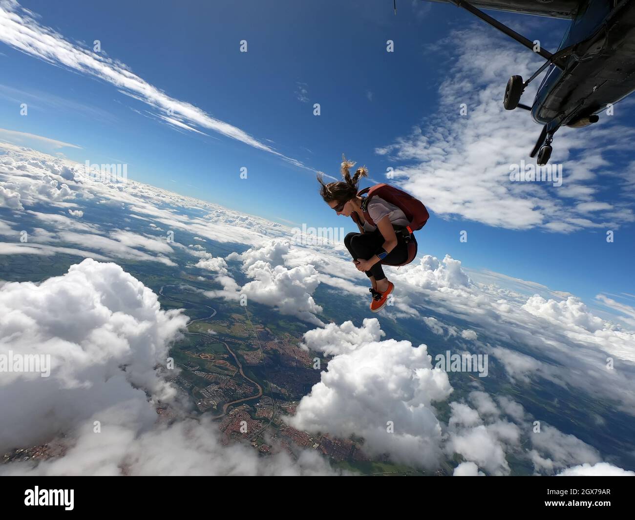 Young woman parachutist smiling in free fall. Perfect concept of happiness and freedom. Stock Photo