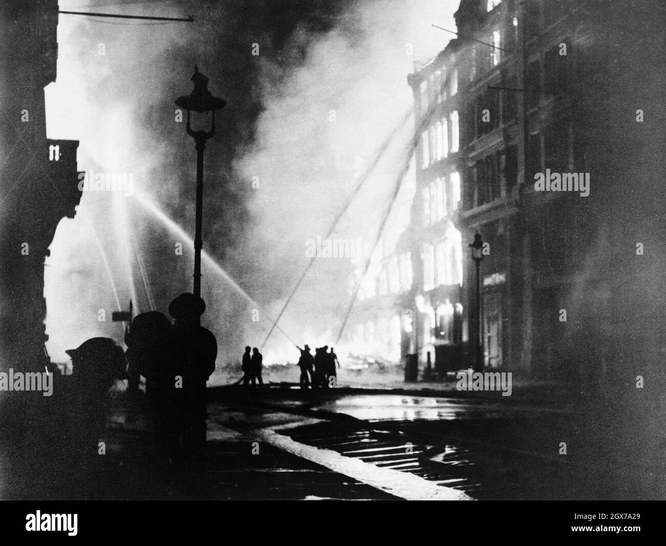 Firemen sparaying water on burning buildings during the London Blitz Stock Photo