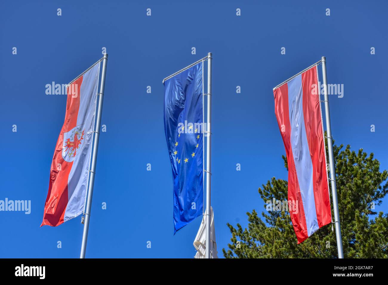 Fahne, Flagge, Österreich, EU, Tirol, wehen, Wind, Stange, Fahnenstange, Nation, Stolz, Zugehörigkeit, Land, rot, weiß, blau, Stern, gelb, Europa, Eur Stock Photo