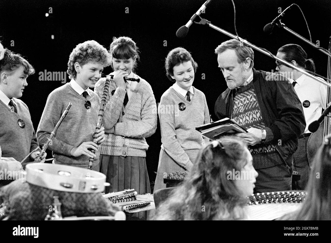 Richard Stilgoe, OBE, English songwriter, lyricist and musician, talking with young musicians during a rehearsal of the Schools Prom at the Royal Albert Hall, London,  in 1987. Stock Photo