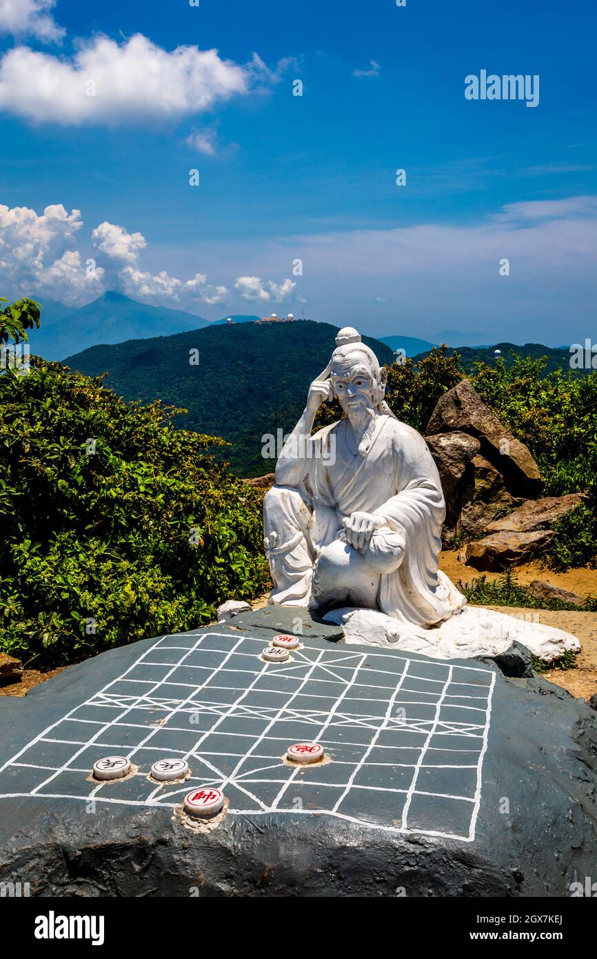 On top of Monkey Moutain sits a statue of Confucious playing a game above the city of Da Nang, Vietnam. Stock Photo