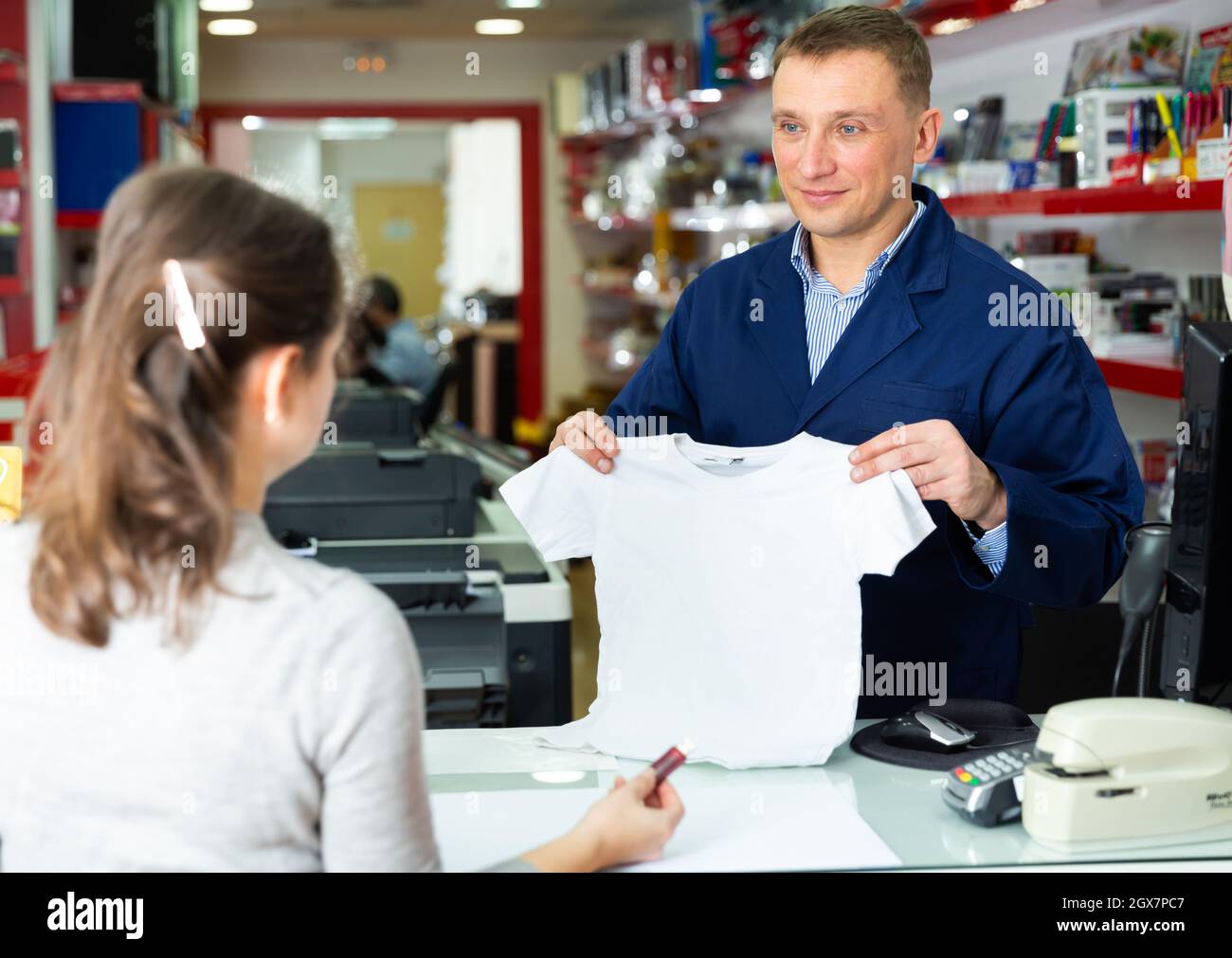 Male administrator offers white t-shirt for drawing picture Stock Photo