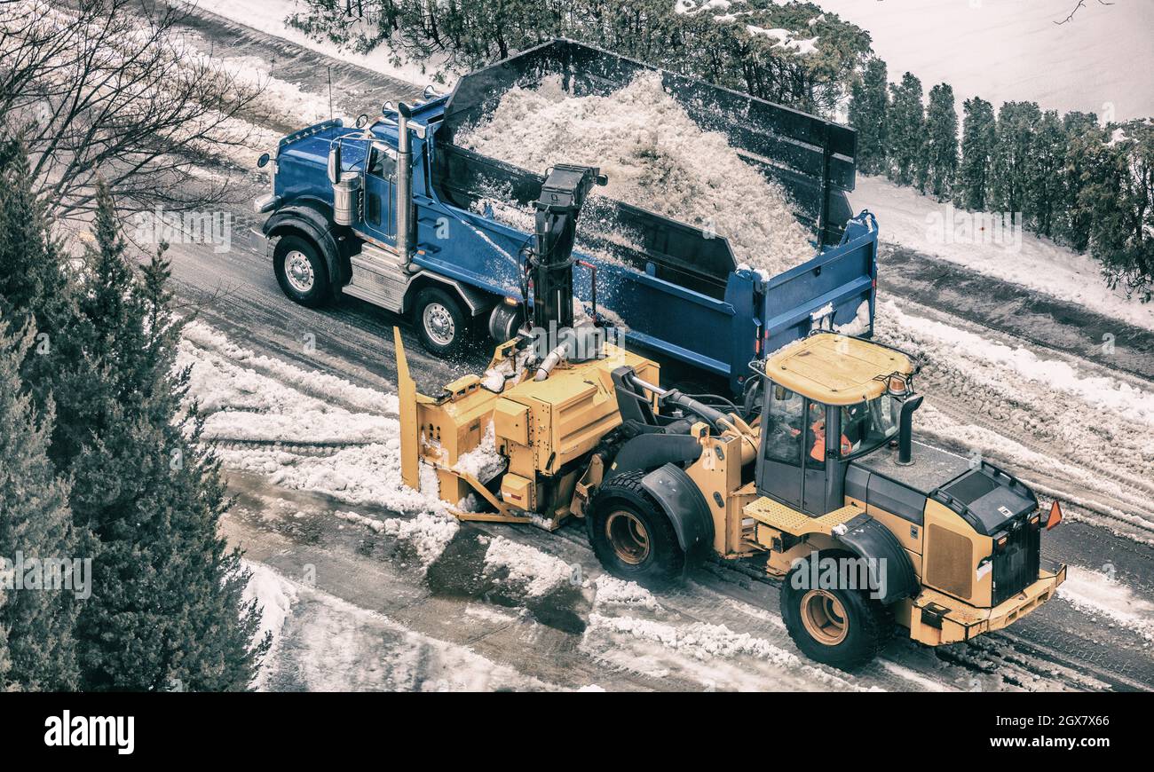 Snow removal plow truck cleaning city street removing snow with