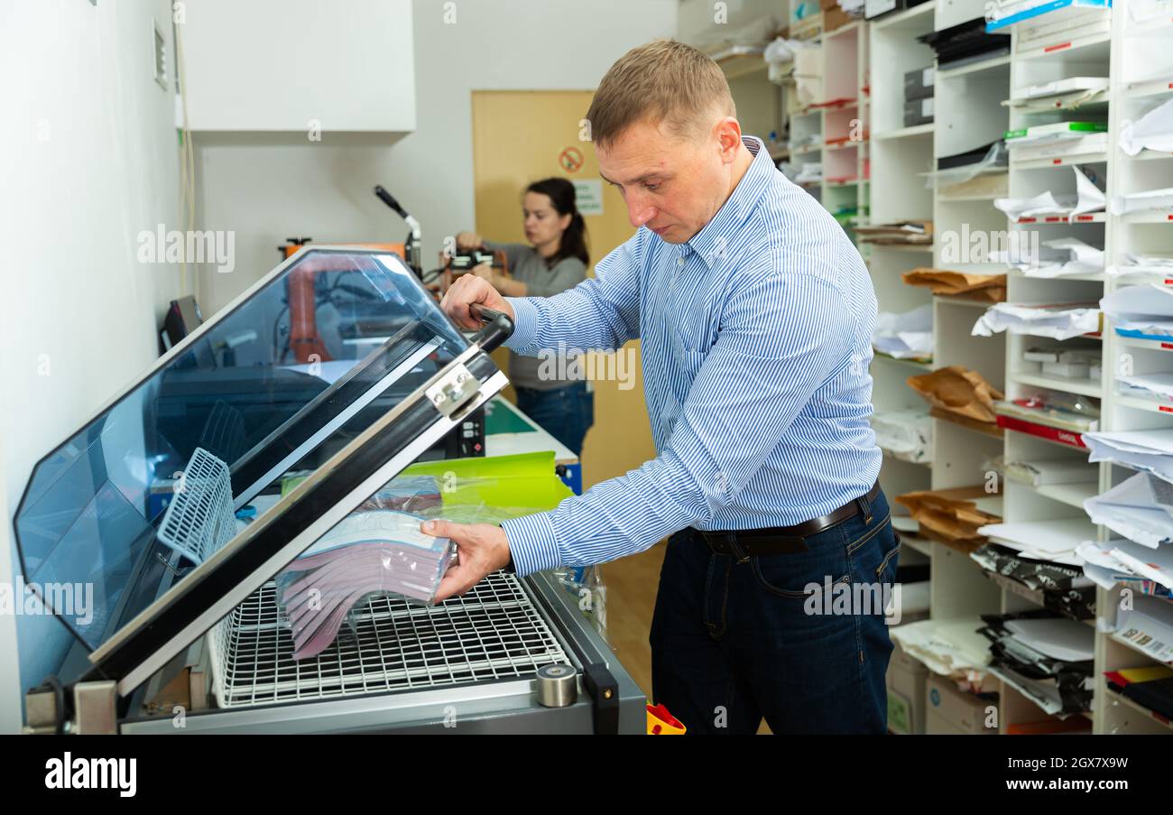 Worker packs notebooks in a vacuum packing Stock Photo