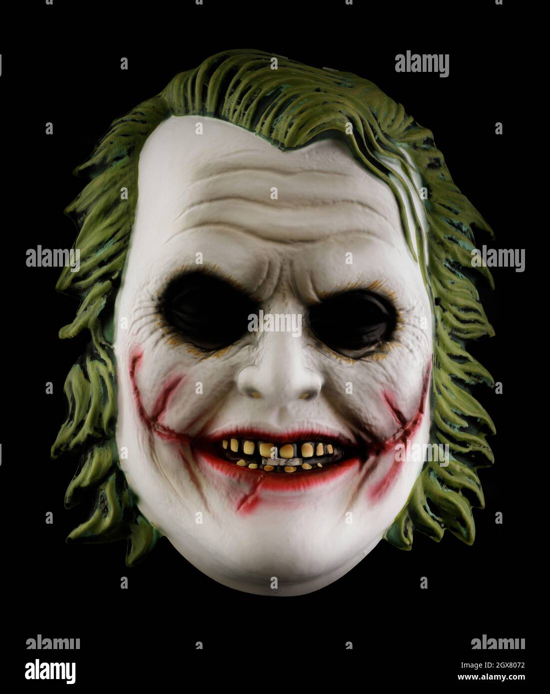The Dark Knight's Joker Mask Isolated on Black Background Stock Photo