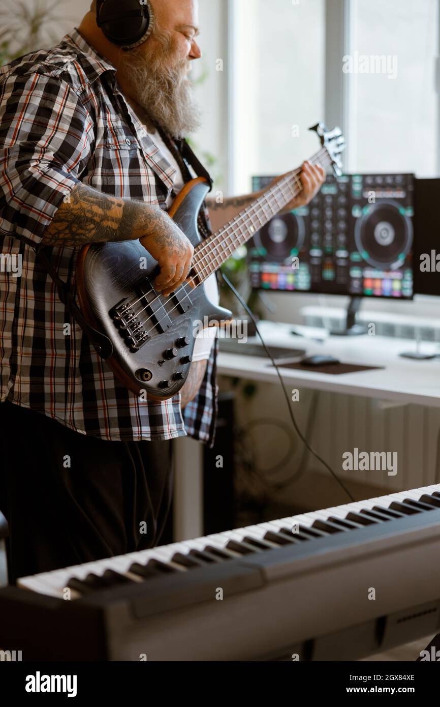Inspired man plays electric guitar recording music with modern