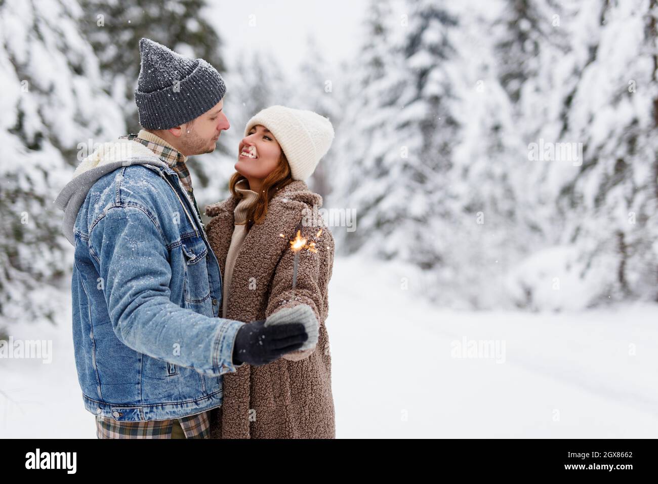 Romantic walk in the winter forest.Young happy couple in love walking in  the winter snowy forest Stock Photo - Alamy