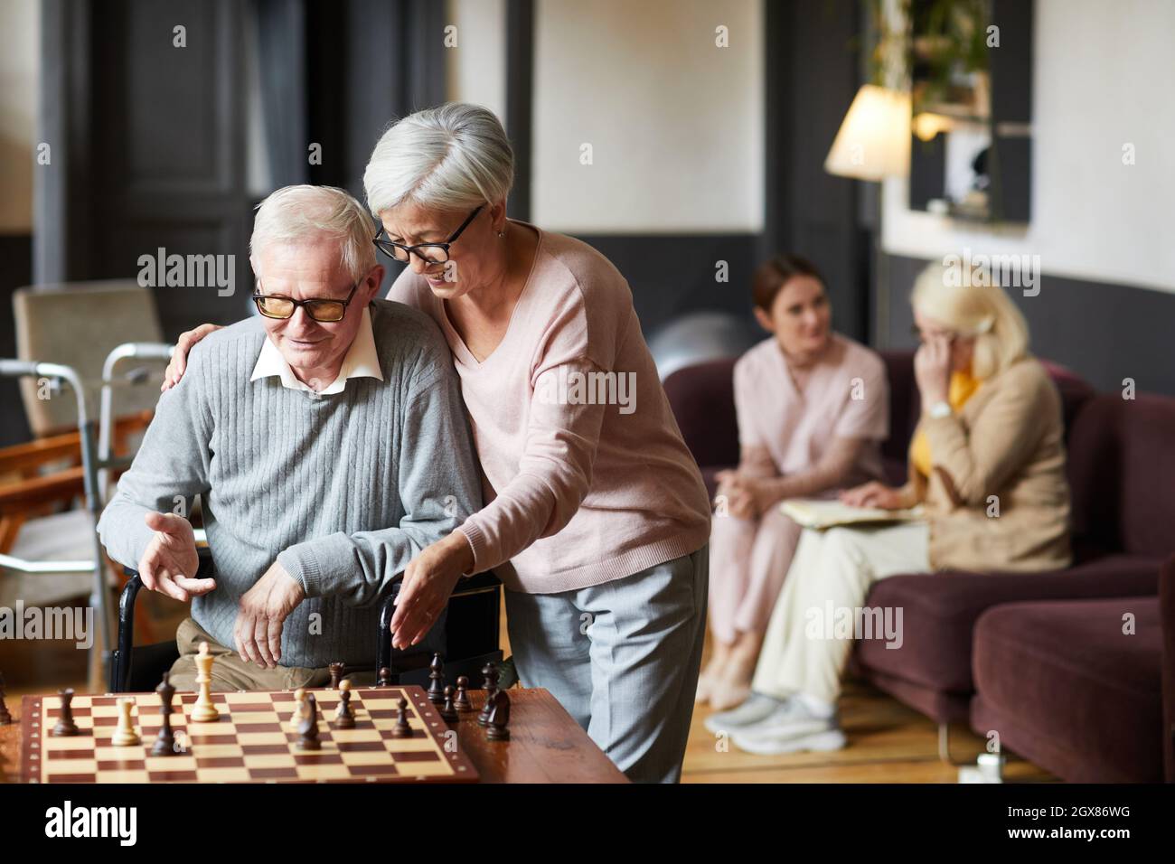 Portrait of two senior people playing chess and enjoying activities in retirement home, copy space Stock Photo