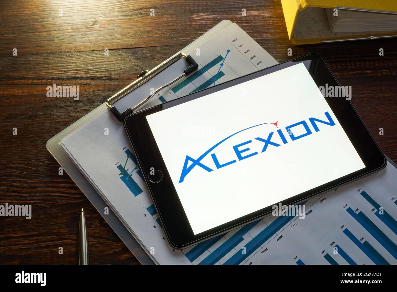 KYIV, UKRAINE - August 21, 2021. Business papers and Alexion Pharmaceuticals logo. Stock Photo