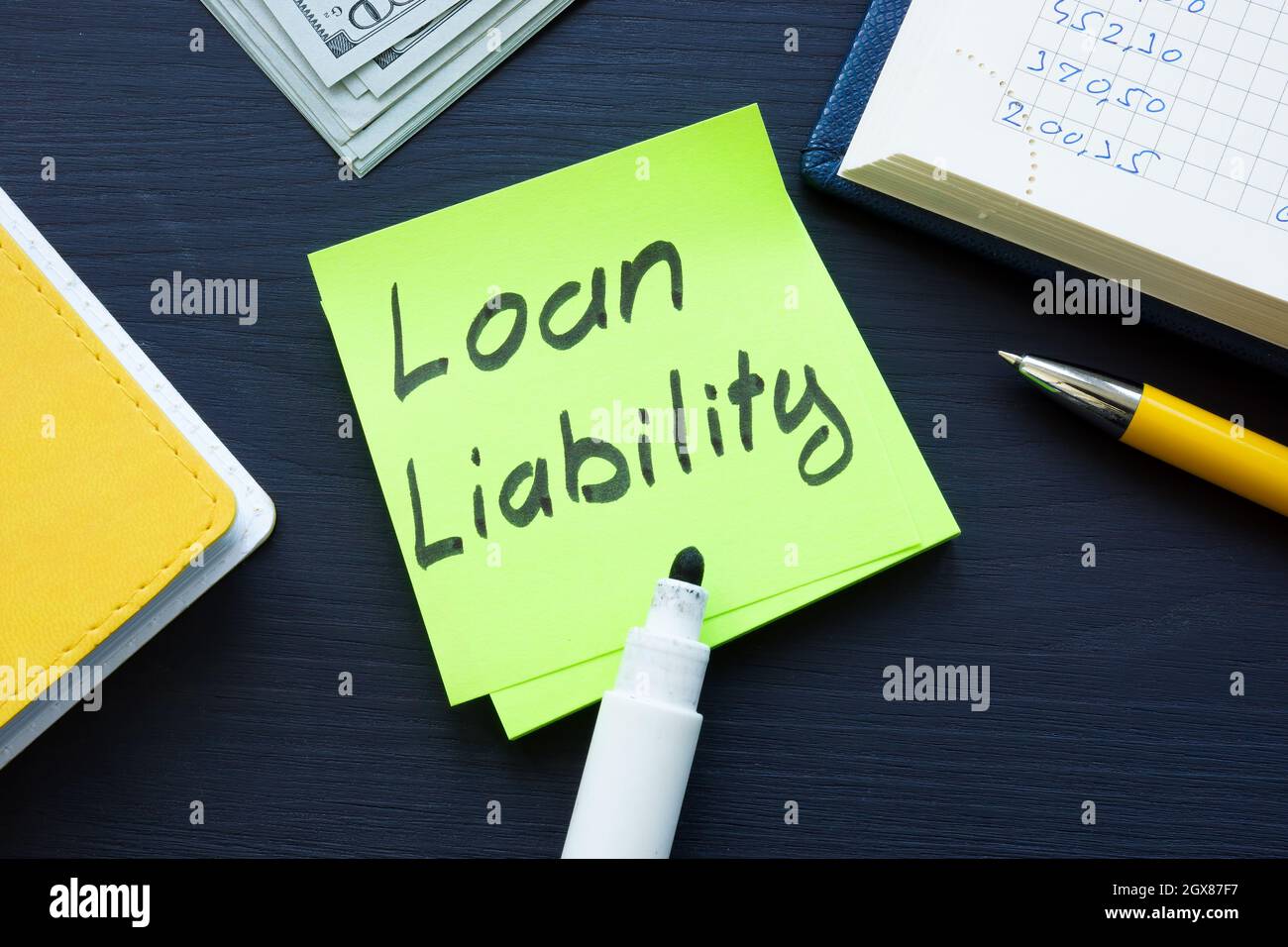 Loan liability memo and cash on the desk. Stock Photo