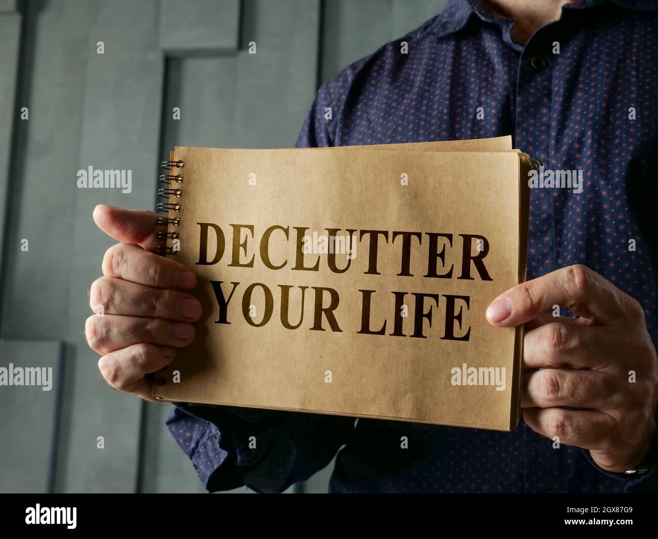 Man shows page with words declutter your life. Stock Photo