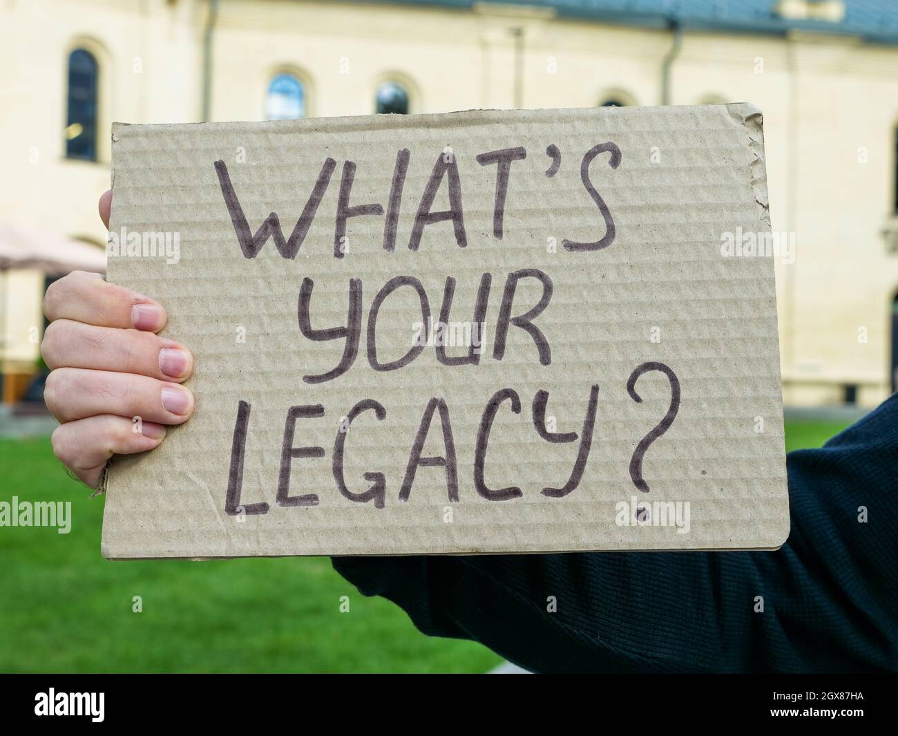 Hand holding a poster What is your legacy. Stock Photo