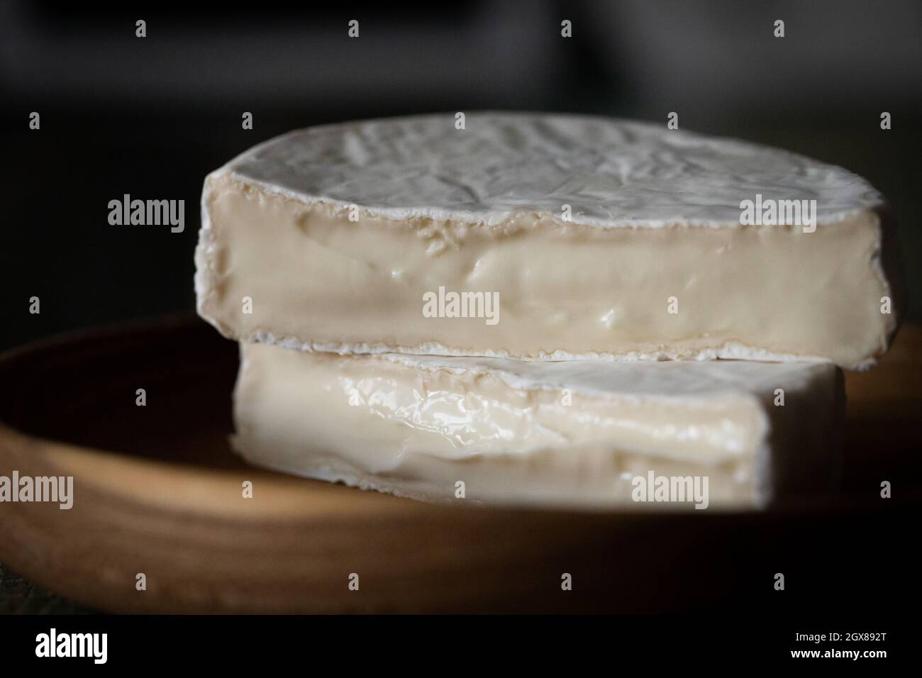 Homemade cheese with white mold on a dark wooden background Stock Photo