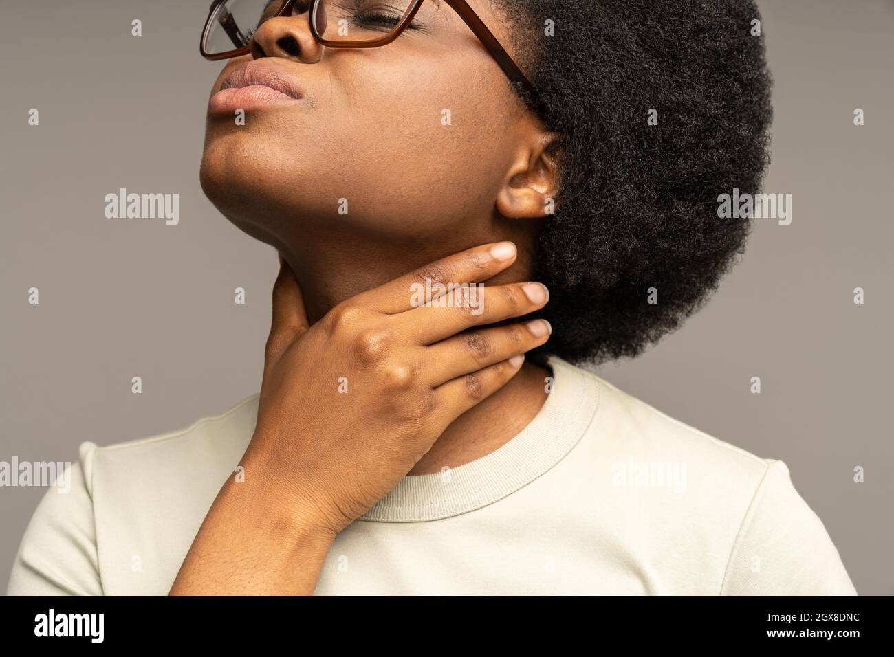 Unhealthy black girl with sore throat touching painful neck suffer from angina or covid-19 disease Stock Photo