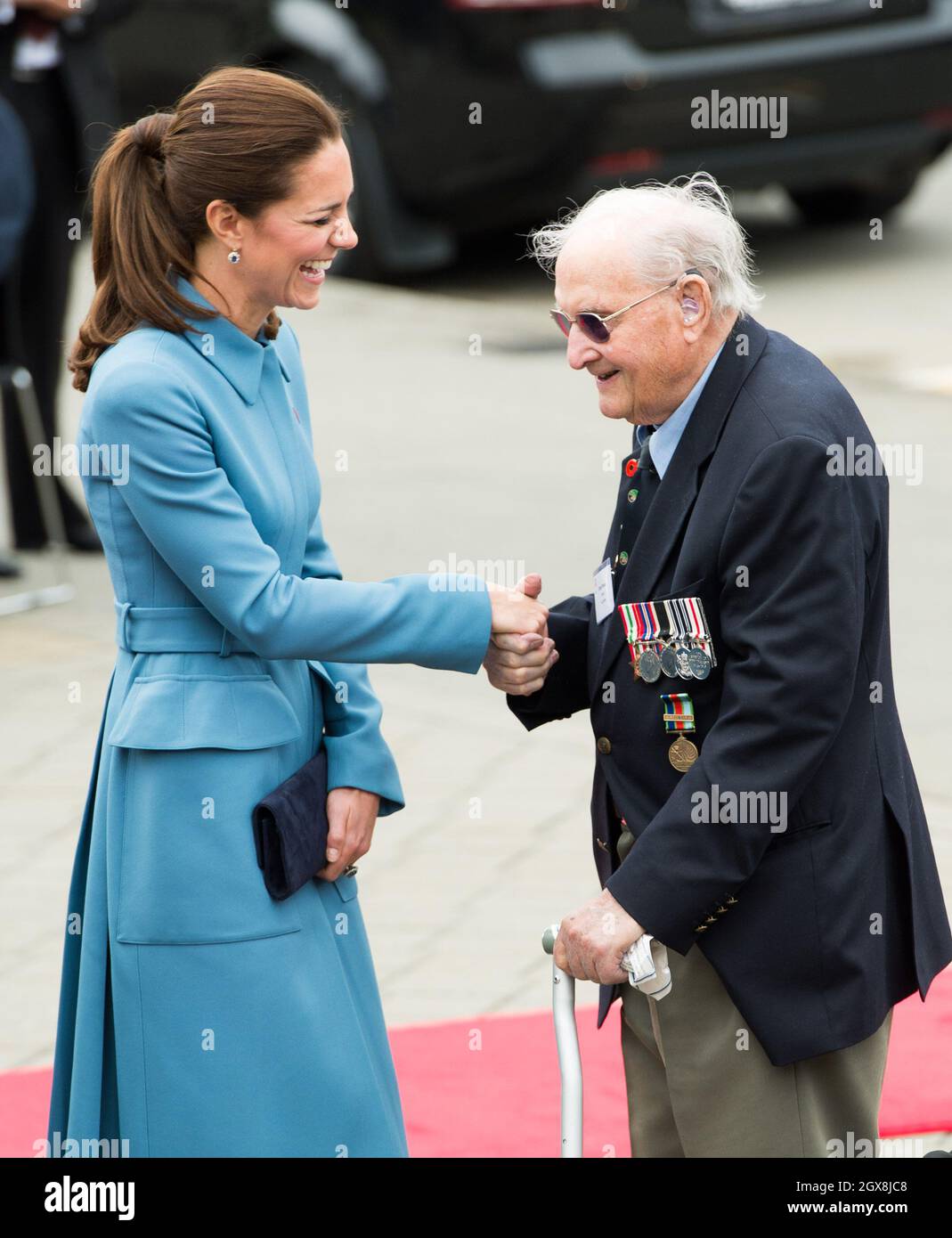 Catherine, Duchess of Cambridge shakes hands with a war veteran during a wreath-laying ceremony and commemoration in Seymour Square, Blenheim, New Zealand on April 10, 2014. The Duchess is wearing a blue coat dress by designer Alexander McQueen. Stock Photo