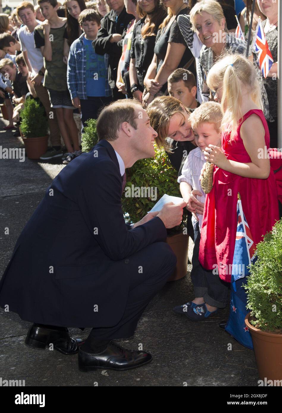Prince William, Duke of Cambridge bends to chat to young children as he visits Pacific Aerospace in Hamilton, New Zealand Stock Photo