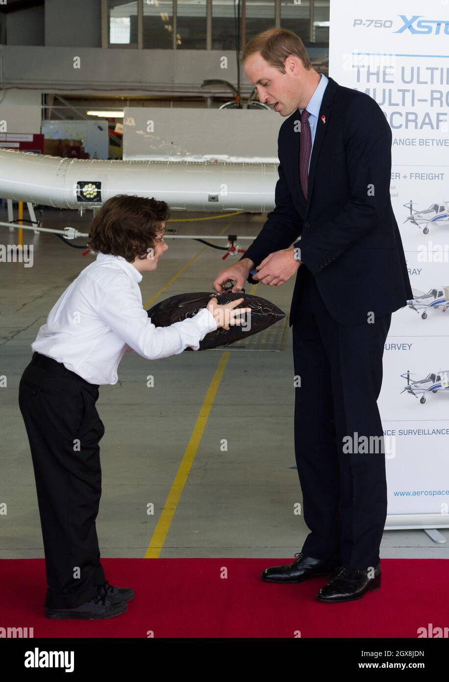 Prince William, Duke of Cambridge receives a gift from a boy during a visit to Pacific Aerospace in Hamilton, New Zealand Stock Photo