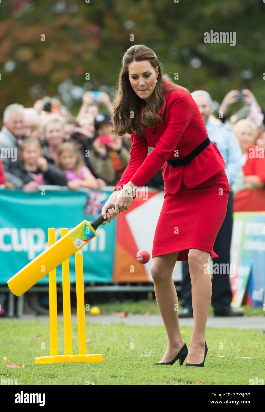 Catherine Duchess of Cambridge, wearing her red Luisa Spagnoli suit, bats during a game of cricket in a 2015 Cricket World Cup event in Christchurch, New Zealand on April 14, 2014.  Stock Photo