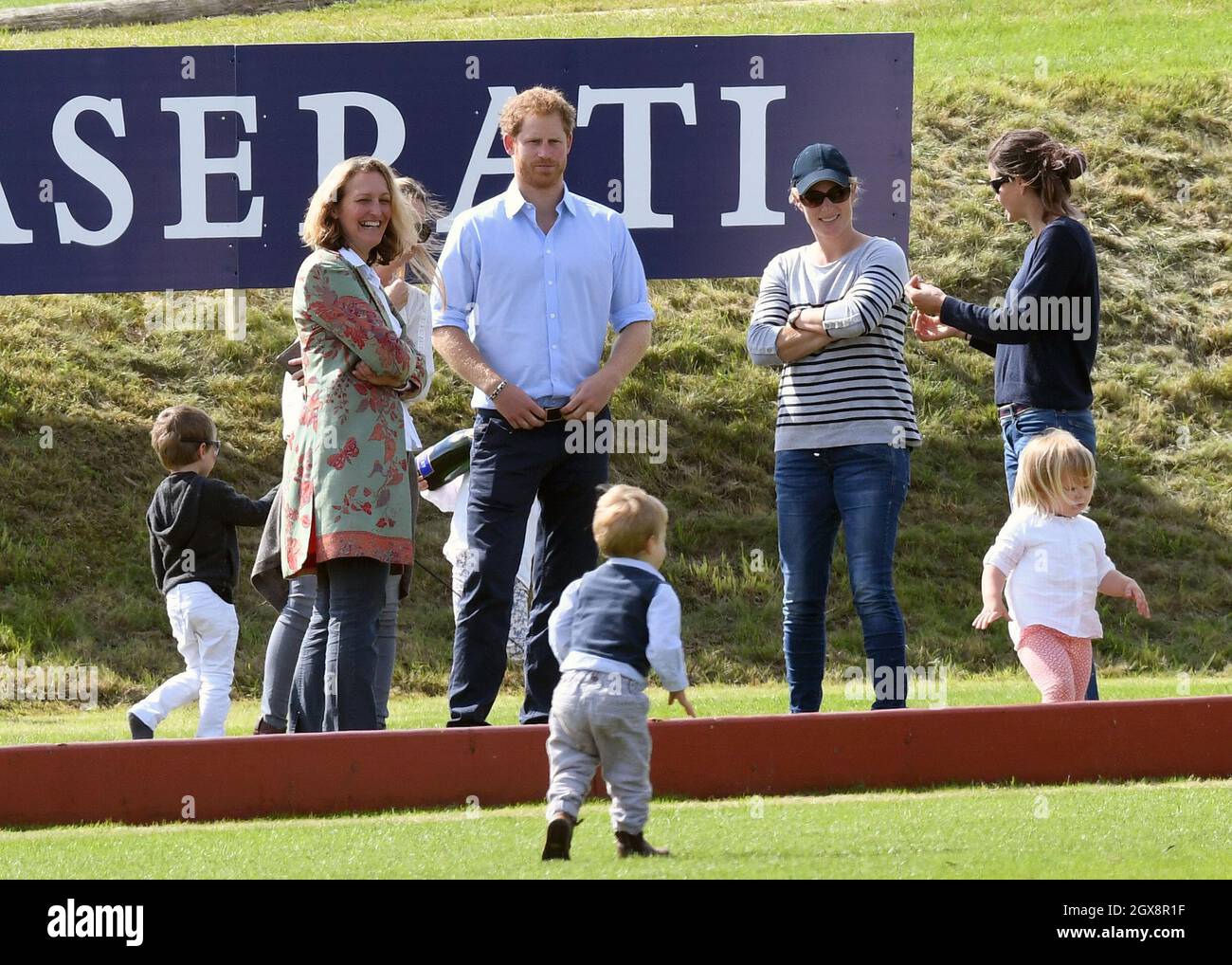 Prince Harry chats with Zara Tindall while Mia Tindall plays during the Maserati Charity Polo match at the Gloucestershire Festival of Polo at the Beaufort Polo Club on June 18, 2016. Stock Photo